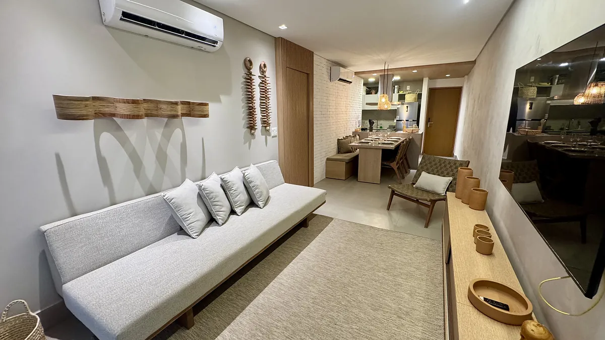 Sala de estar com sof\u00e1 claro, tapete de fibra e marcenaria em madeira.